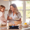 Mother And Daughter Making Pancakes In Kitchen At Home Together