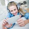 Woman social networking at home and wearing headphones