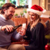 Loving Couple Celebrating With Champagne Around Christmas Tree At Home