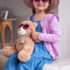 Portrait Of Young Girl Wearing Hat And Sunglasses Having Fun Playing With Dressing Up Box At Home