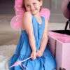 Young Girl Wearing Fairy Wings Having Fun Playing With Dressing Up Box At Home