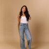 trinh-nguyen-2 A smiling woman with long dark hair poses confidently against a neutral studio backdrop wearing casual attire.