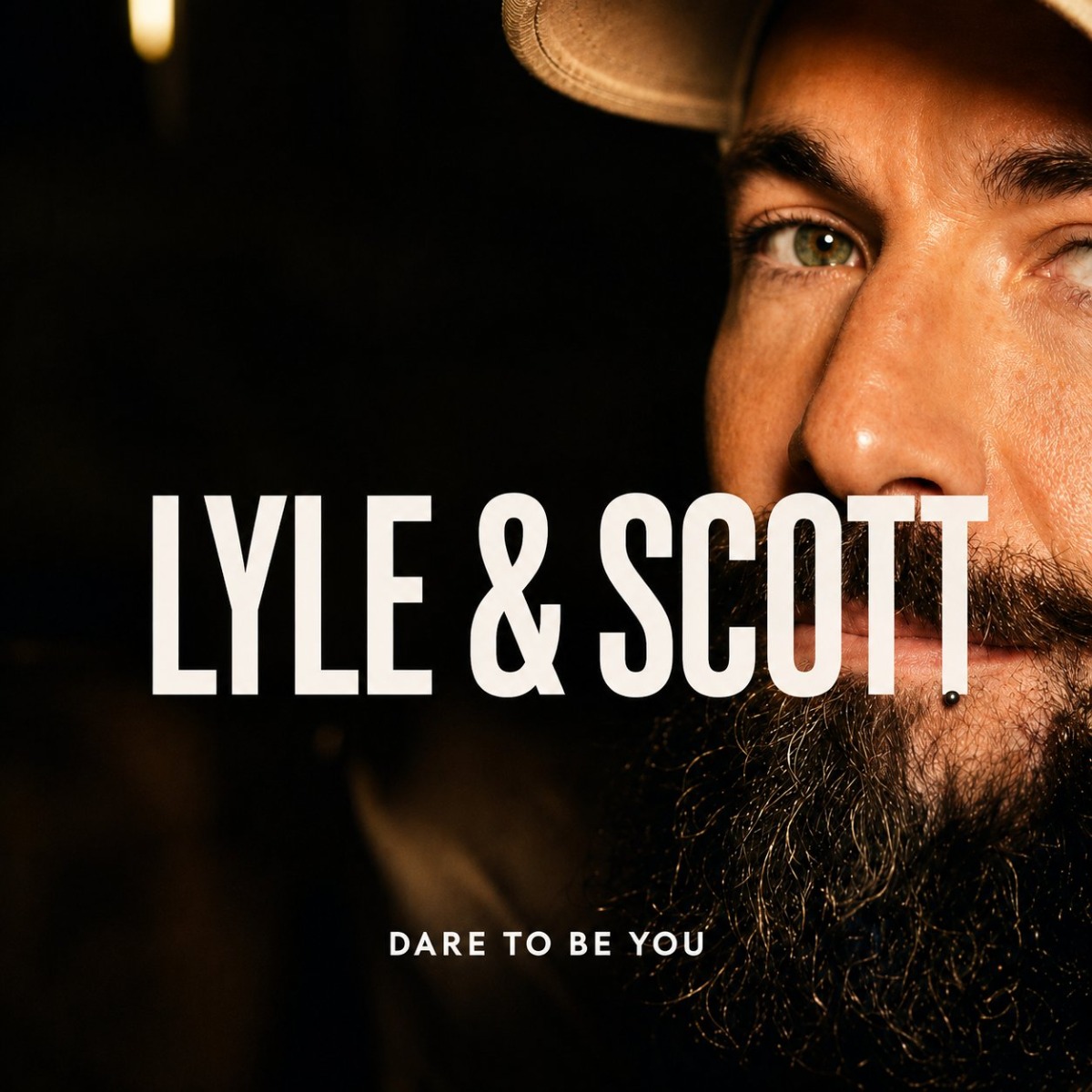 A close up cropped advertising shot of a bearded male model featuring Lyle and Scott brand text.
