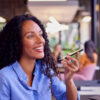 Businesswoman Sitting At Desk In Office Talking Into Mic Of Mobile Phone