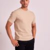 abdul-wadid-2 A man wearing a beige t-shirt poses confidently against a neutral light grey studio background.