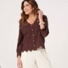 rachael-warner-3 A smiling brunette woman wearing a brown lace blouse against a clean bright studio background.