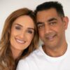 A happy diverse couple smiling at the camera in a bright, clean, and professional studio setting.