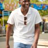 deondre-cumberbatch-8 A smiling man wearing a white polo shirt walks outside at a bright, sunny local amusement park.