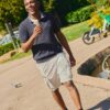 deondre-cumberbatch-6 A smiling man enjoys an ice cream while walking through a bright and sunny public park.