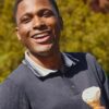 deondre-cumberbatch-5 A smiling man holding an ice cream cone outdoors, looking friendly, warm, and relaxed in natural sunlight.
