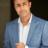mohan-randhawa-3 A well-dressed man in a blue suit looks away thoughtfully in this professional commercial headshot portrait.