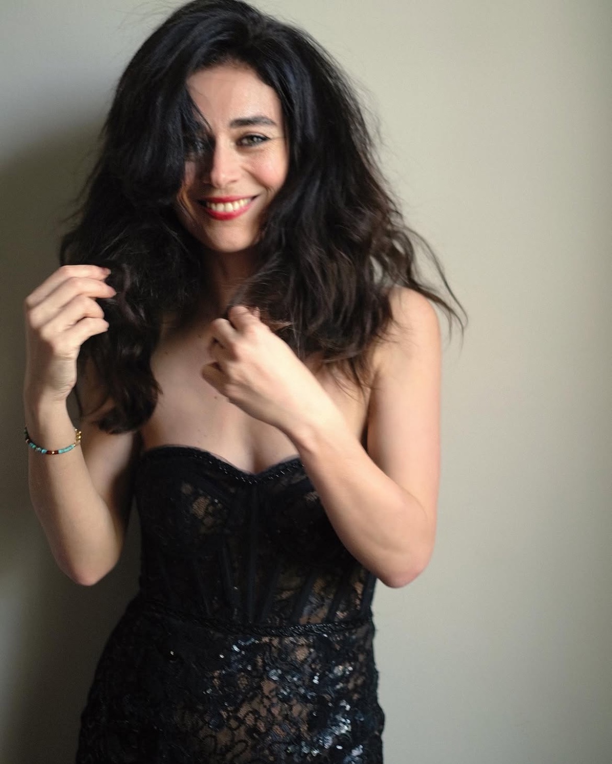 helena-antonio-10 A charismatic woman with dark flowing hair smiles naturally while wearing a stylish black lace bodice top.