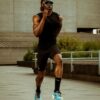 tobi-thomas-10 A fit male athlete running outdoors in sportswear with bright modern sunglasses in a concrete urban setting.