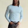 tobi-thomas-14 A stylish Black male model with braided hair wears a light blue sweater against a neutral background.