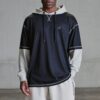 tobi-thomas-8 A male model posing in casual sportswear against a neutral grey studio background for a commercial shoot.